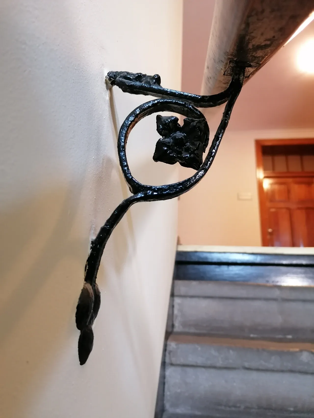 Black painted bracket supporting a handrail beside a stair at the Franciscan monastery in Katowice Panewniki, Poland, photographed in May 2024