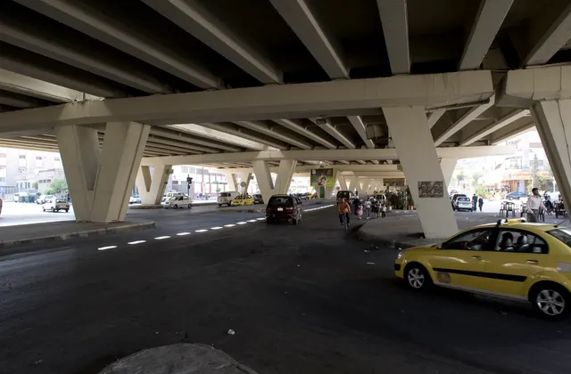 Vehicles and pedestrians beneath an elevated road in Damascus al-Midan, photographed in September 2008