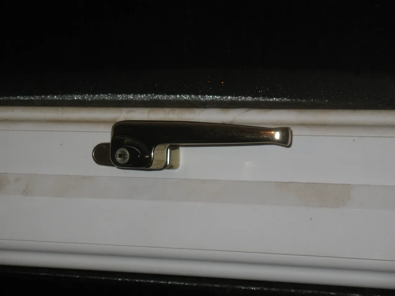 Window handle and visible lock on a white frame, photographed in November 2013