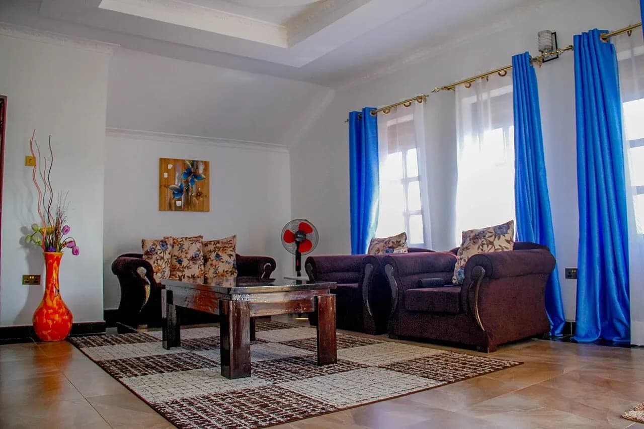 Furnished living room with sofas, a coffee table, patterned rug and blue curtains