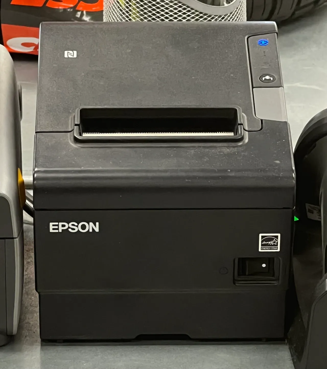 Black receipt printer on a counter, photographed in June 2026