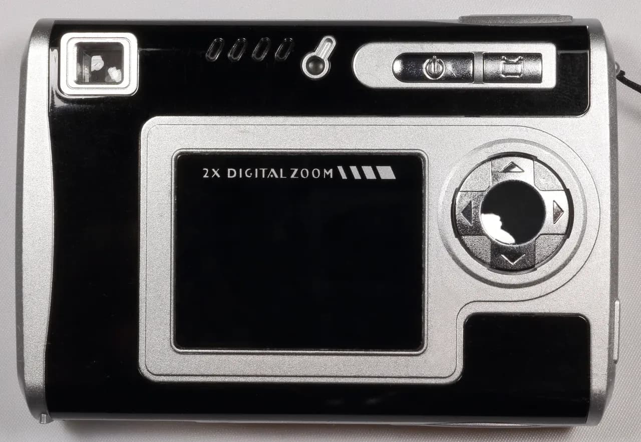 Rear of a compact digital camera with a dark screen and physical controls