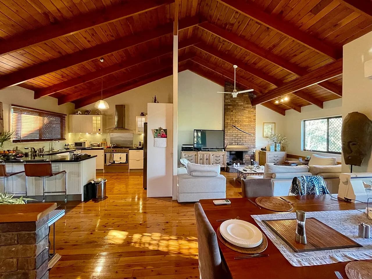 Open-plan kitchen and sitting space with a wooden ceiling in a house in Corinda, Queensland, Australia