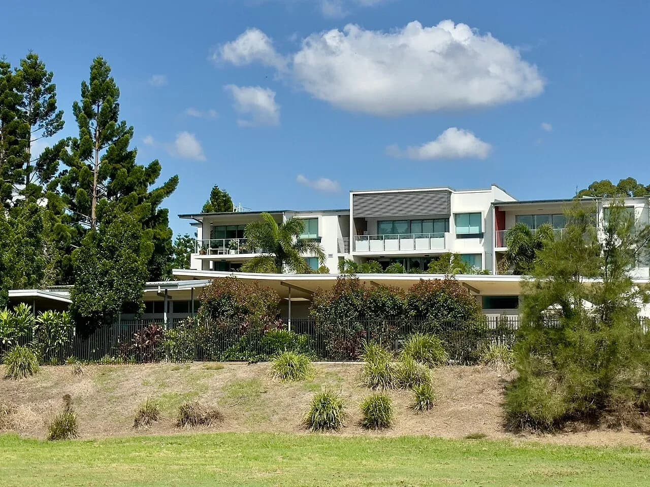 Closer apartment-building exterior view with balconies and planted grounds in Sherwood, Brisbane, Australia