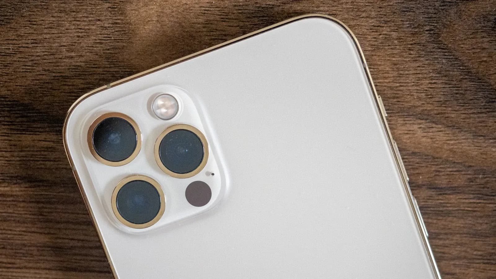 Close view of smartphone camera lenses on a wooden surface, October 2020