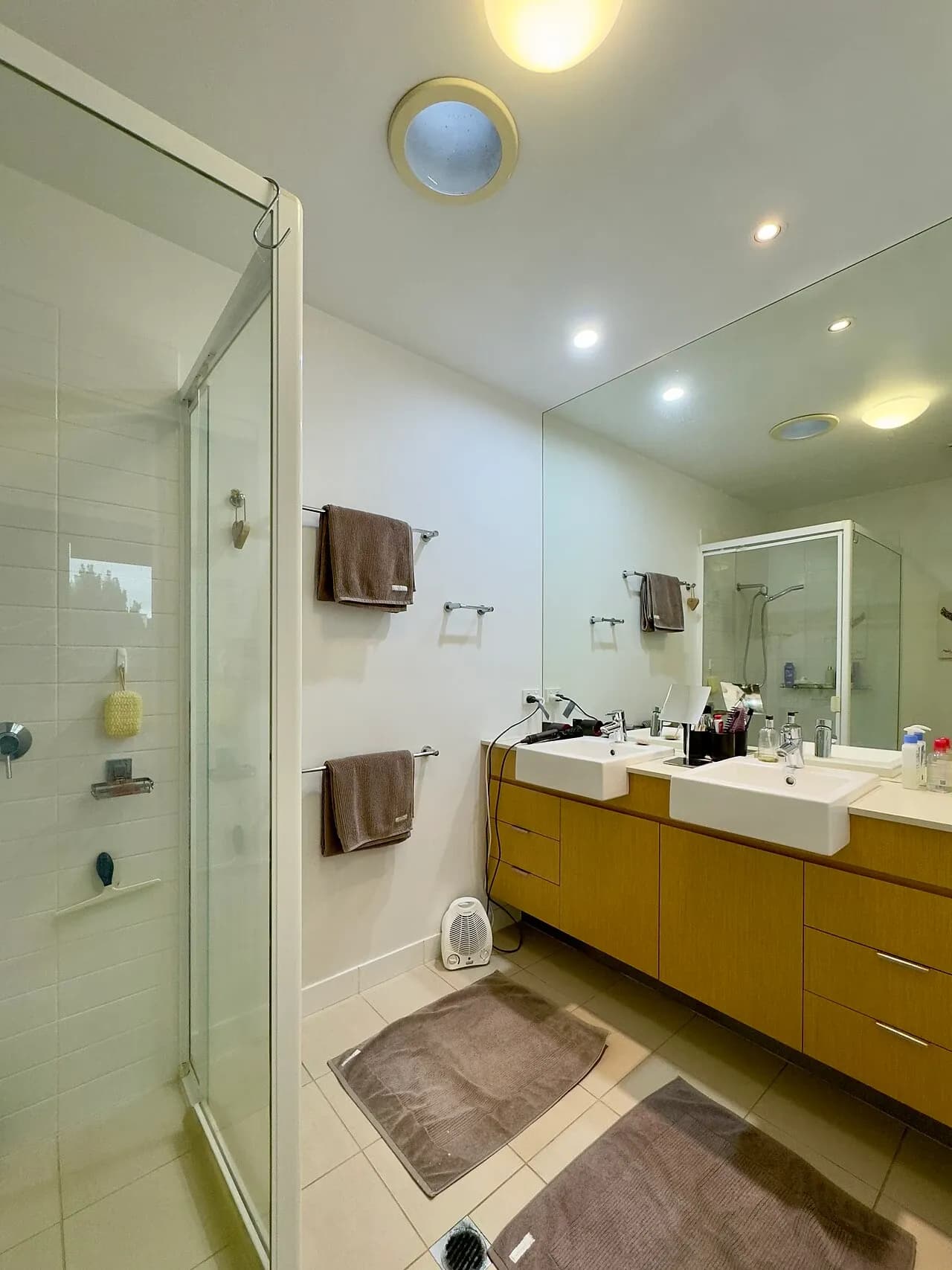 Shower enclosure, basins and mirror in a Brisbane apartment bathroom, June 2025