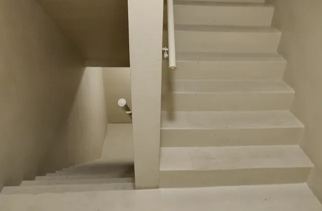 Two stair flights beside a dividing wall and handrails in a Washington, DC apartment building, photographed in March 2020