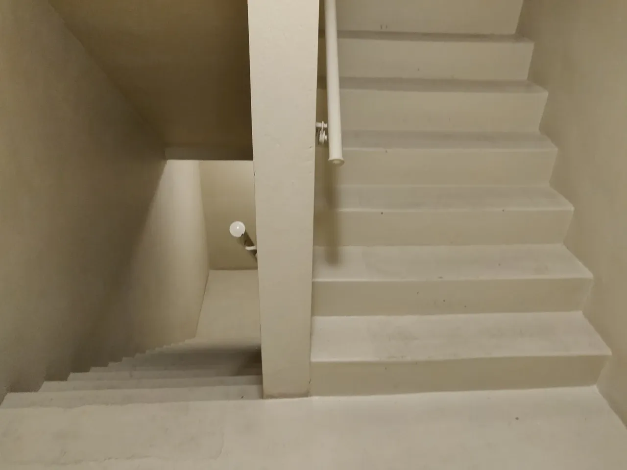Two stair flights beside a dividing wall and handrails in a Washington, DC apartment building, photographed in March 2020