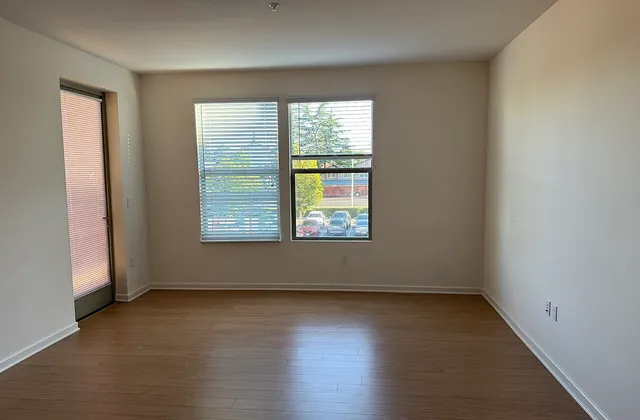 Unfurnished apartment room with a window, glazed outside door and wall sockets