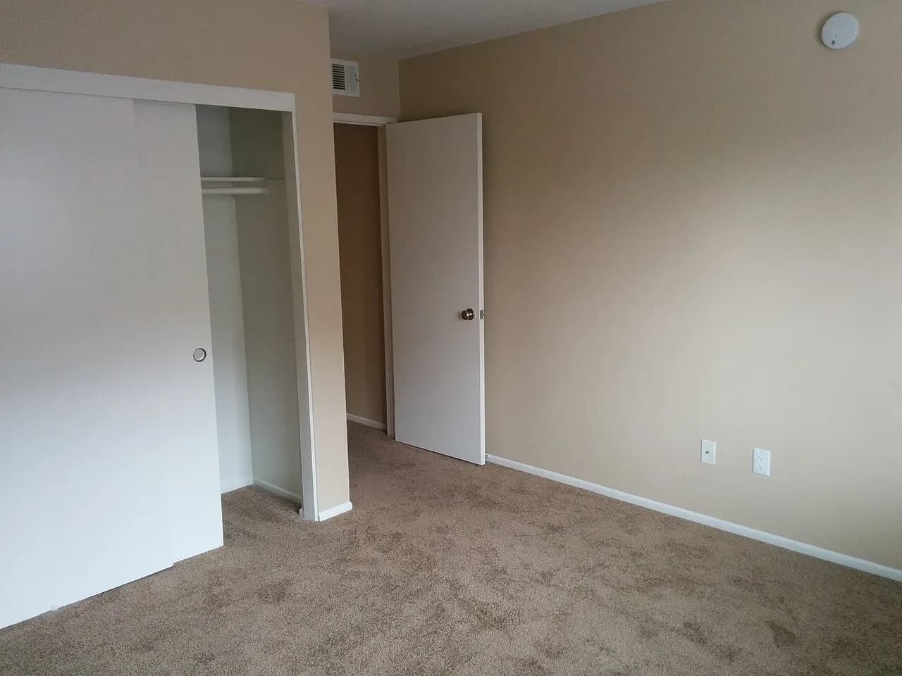 Unfurnished carpeted room with an open closet and doorway in Riverside, California, photographed in May 2017