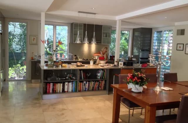Open-plan kitchen and dining room in Brisbane with an island, windows and a person in the background, February 2014