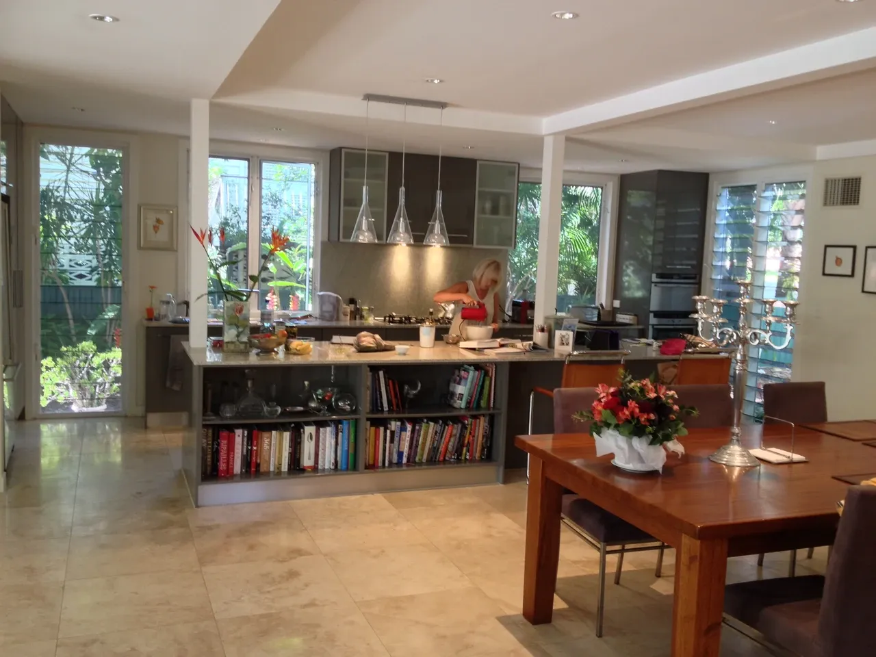 Open-plan kitchen and dining room in Brisbane with an island, windows and a person in the background, February 2014