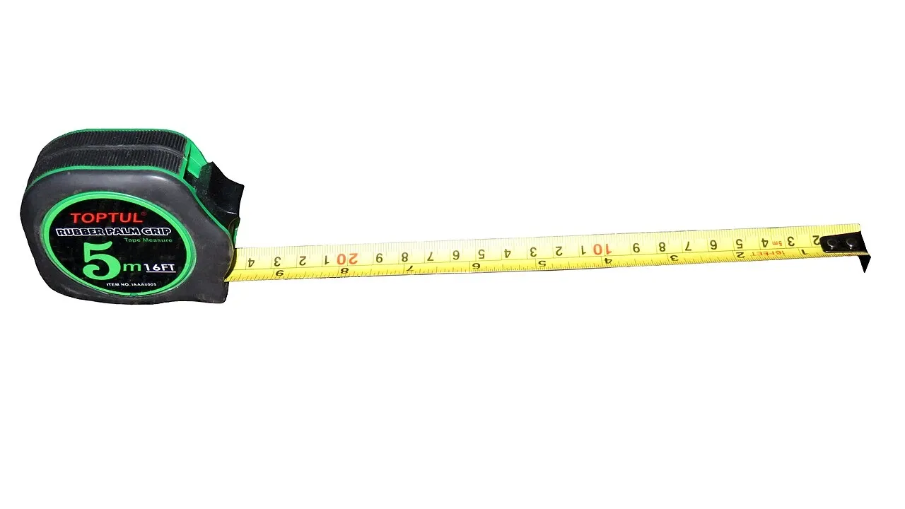 Green and black retractable tape measure with its yellow tape extended on a white background