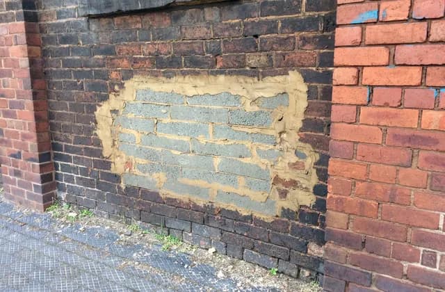 Concrete block infill surrounded by older red brickwork on Corn Hill, Wolverhampton, March 2021
