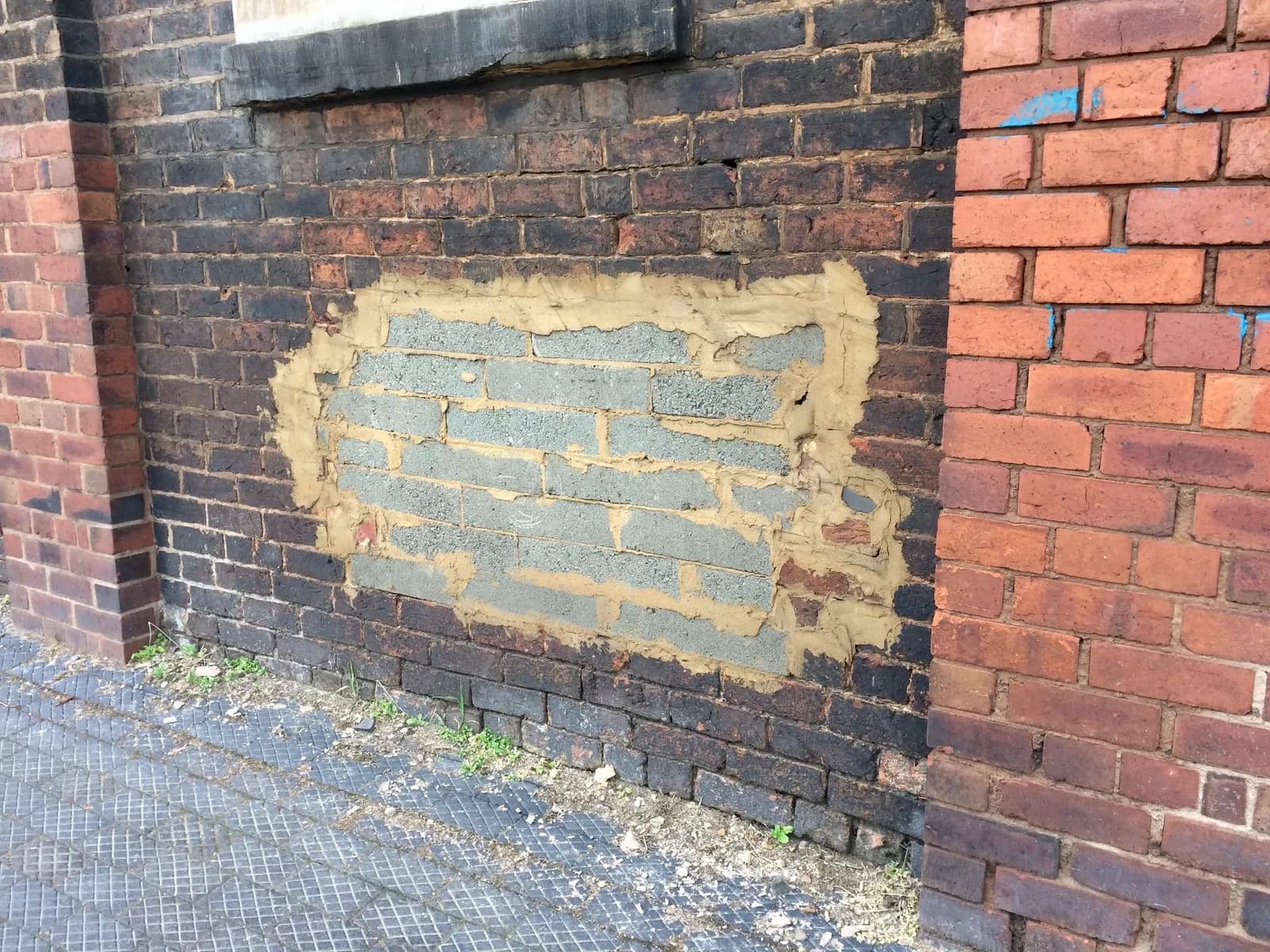 Concrete block infill surrounded by older red brickwork on Corn Hill, Wolverhampton, March 2021